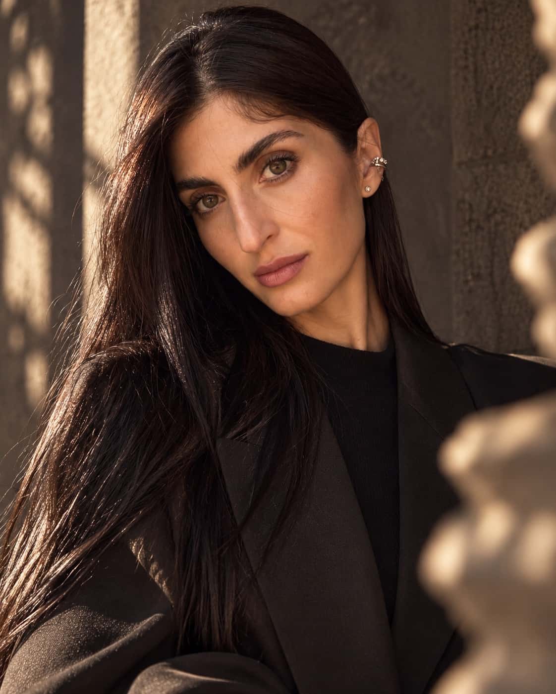Portrait of Kristina Ellarian in a black suit and warm cinematic light